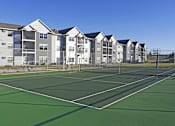 Thumbnail 6 of 18 - Tennis with basketball hoop and fencing at Cypress Court Apartments, St Cloud, Minnesota