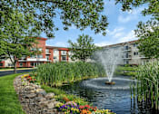Thumbnail 1 of 14 - Fountain and pond with landscaped grounds at Grand Gateway Apartments, St Cloud, MN 56301