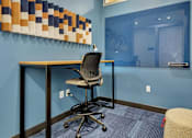 Thumbnail 12 of 40 - Private workspace with standing desk and acoustic wall art at Prosper West Apartments, Waite Park, MN