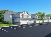 Thumbnail 1 of 25 - Townhome style buildings with attached garages and parking lot at Regency Park Apartments, St Cloud, MN