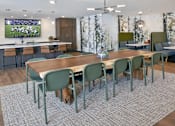 Thumbnail 6 of 25 - Clubhouse dining area with large wood table and modern chairs at Regency Park Apartments, St Cloud, MN