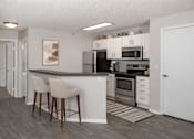 Thumbnail 21 of 25 - Modern kitchen with breakfast bar and stainless appliances at Regency Park Apartments, St Cloud, 56304