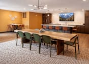 Thumbnail 7 of 25 - Community room with dining tables and kitchen bar at Regency Park Apartments, St Cloud, 56304