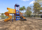 Thumbnail 22 of 23 - a playground with a yellow slide and a blue playset