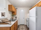 Thumbnail 14 of 17 - A kitchen with a white refrigerator and wooden cabinets.