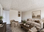 Thumbnail 13 of 17 - A living room with a couch, chair, and coffee table.