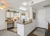 Thumbnail 19 of 24 - A kitchen with white walls and a white door.
