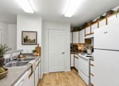Thumbnail 8 of 16 - A kitchen with white appliances and wooden floors at Slate Canyon Apartments, Utah, 84606