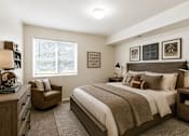 Thumbnail 10 of 16 - A bedroom with a bed, chair, and two framed pictures on the wall at Slate Canyon Apartments, Provo, UT, 84606