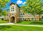Thumbnail 3 of 16 - A large building with a tree in front of it at Slate Canyon Apartments, Utah