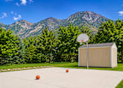 Thumbnail 4 of 16 - A basketball court with a basketball hoop and two balls on the ground at Slate Canyon Apartments, Provo