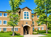Thumbnail 2 of 16 - A large building with a brown and tan facade and a large arched entrance. at Slate Canyon Apartments, Apartments, Provo, UT