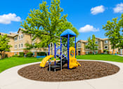 Thumbnail 5 of 16 - A playground with a blue and yellow slide in the middle of a circular play area at Slate Canyon Apartments, Utah, 84606