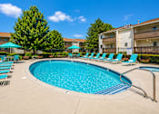 Thumbnail 6 of 17 - A swimming pool surrounded by chairs and trees.