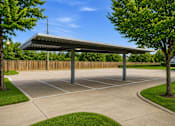 Thumbnail 5 of 17 - A parking lot with a canopy and a fence.