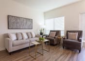 Thumbnail 2 of 26 - A living room with a grey couch, two chairs and a coffee table.
