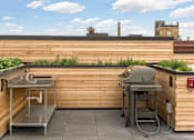 Thumbnail 10 of 36 - A small outdoor kitchen with a sink and grill.