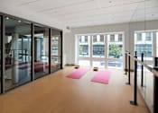 Thumbnail 22 of 36 - A yoga studio with pink mats and glass walls.