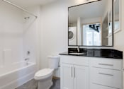 Thumbnail 36 of 36 - A white bathroom with a toilet, sink, and bathtub.