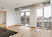 Thumbnail 24 of 36 - A room with a black table and a view of the city through the windows.