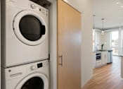 Thumbnail 31 of 36 - A white washing machine and dryer stacked on top of each other in a kitchen.