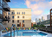 Thumbnail 22 of 43 - A swimming pool on a balcony with a view of the city.