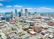 Thumbnail 26 of 43 - A cityscape with a mix of modern and older buildings under a clear sky.