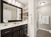 Thumbnail 15 of 43 - A bathroom with a white sink and a mirror above it.