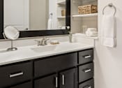 Thumbnail 16 of 43 - A bathroom with a sink, mirror, and lights.