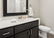 Thumbnail 20 of 43 - A bathroom with a white countertop and a white toilet.