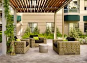 Thumbnail 9 of 40 - A patio with a wooden roof and wicker furniture.