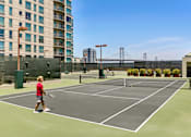 Thumbnail 27 of 40 - A tennis court with a person playing tennis.