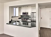 Thumbnail 4 of 40 - A modern kitchen with a refrigerator, sink, and stove.