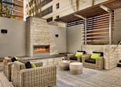 Thumbnail 12 of 40 - A patio with a fireplace and wicker chairs.