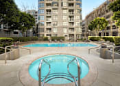Thumbnail 11 of 40 - A small pool in a courtyard surrounded by buildings.