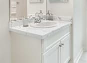 Thumbnail 35 of 40 - A white bathroom with a sink and mirror.