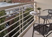 Thumbnail 6 of 40 - A balcony with a table and chairs overlooking a cityscape.