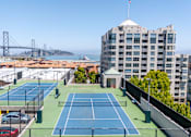 Thumbnail 9 of 95 - A tennis court is located on the roof of a building.