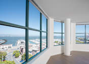Thumbnail 1 of 95 - A room with a large window overlooking a harbor.