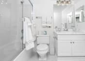 Thumbnail 16 of 95 - A white bathroom with a toilet, sink, and bathtub.