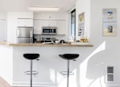 Thumbnail 13 of 95 - A kitchen with a bar stool in front of a counter.