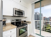 Thumbnail 59 of 95 - A kitchen with white cabinets and stainless steel appliances.
