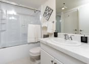 Thumbnail 67 of 95 - A white bathroom with a toilet, sink, and shower.