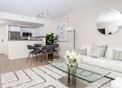 Thumbnail 68 of 95 - A modern living room with a glass coffee table and a white sofa.