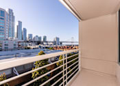 Thumbnail 72 of 95 - A balcony overlooks a cityscape with a bridge in the distance.