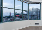 Thumbnail 73 of 95 - A room with a large window overlooking a cityscape.