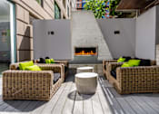 Thumbnail 31 of 95 - A patio with a fireplace and wicker chairs.