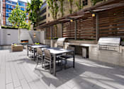 Thumbnail 34 of 95 - A patio with a table and chairs and a grill.