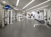 Thumbnail 44 of 95 - A gym with a variety of equipment including a leg press machine.