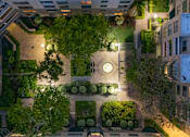 Thumbnail 88 of 95 - A courtyard surrounded by buildings with a clock on the wall.